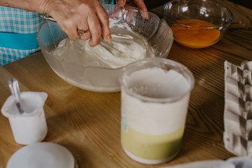 adult woman in the kitchen kneading the mix for sweets and desserts