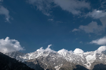 Fototapeta na wymiar Snowy peaks of the Himalayas. Travelling to Himachal Pradesh. View from the mountain pass Triund.