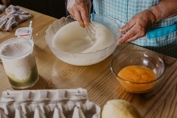 adult woman in the kitchen kneading the mix for sweets and desserts