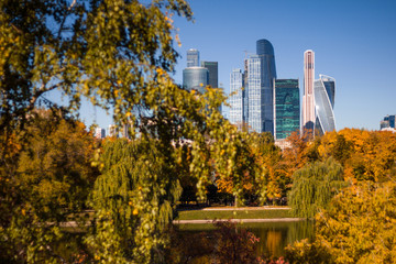 Beautiful view of the business center of Moscow city from the Novodevichy convent Park on the background of yellowed autumn trees and blue sky. Autumn landscape.