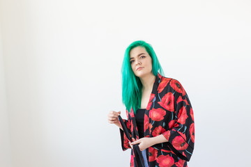 Portrait, fashion and hair coloring concept - young woman with green hair dressed kimono over the white background with copy space