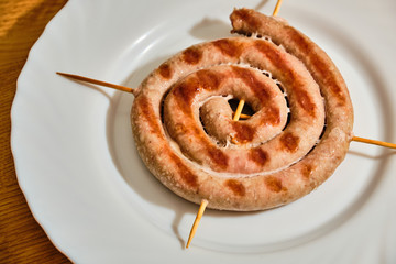 Spiral sausages on white plate