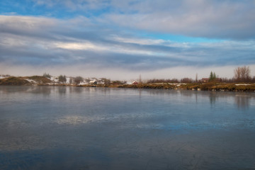 Naklejka premium beautiful winter landscape on an icy lake with holiday cabins