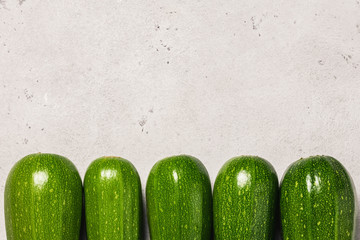 Zucchini on concrete background. Top view, space for text.