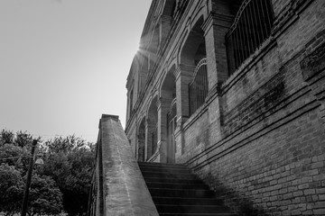 OLD BUILDING OF BRICK WITH EXTERIOR STAIRS BLACK AND WHITE PHOTOGRAPHY