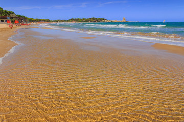 Apulia beach: Bay of Sfinale, between Peschici and Vieste, with an ancient Torre Saracena, typical lookout tower of the coast of Gargano, Italy.