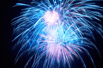 Blue holiday fireworks on black sky background