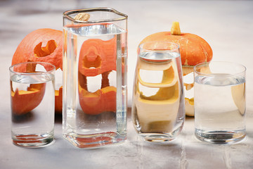 Pumkin distorted through liquid and glass on white background. Carving A Pumpkin For Halloween.