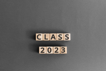 Class 2023 - word from wooden blocks with letters, Class of 2023 concept,  grey background