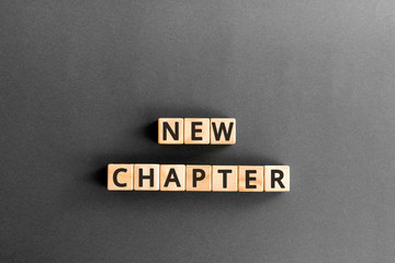 new chapter - words from wooden blocks with letters, starting new life new chapter concept,  grey...