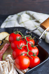 Fresh cherry tomatoes grill pan as cooking ingredients for dish on a dark background with napkin