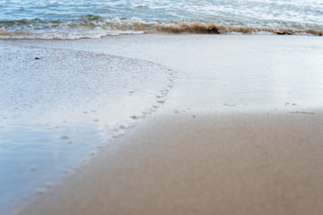 Beautiful waves rolling up on a sandy beach. Summertime in Österlen, Sweden.