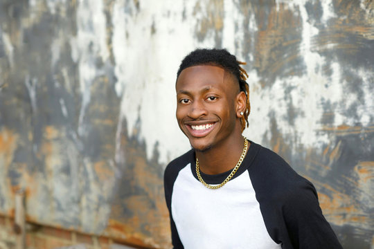 happy African-American Teen Teenager male Man outside in a baseball jersey henley
