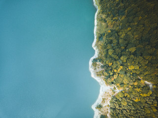 Aerial view of a forest lake. Aerial view of blue lake and green forests on a sunny summer day....