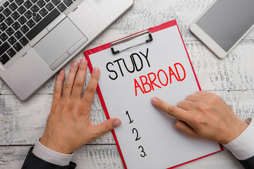 Writing note showing Study Abroad. Business concept for Pursuing educational opportunities in a...