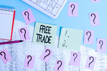 Conceptual hand writing showing Free Trade. Concept meaning The ability to buy and sell on your own terms and means Writing tools and scribbled paper on top of the wooden table