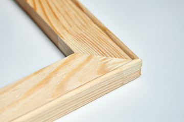 Corner of a wooden stretcher bar for canvas on grey background