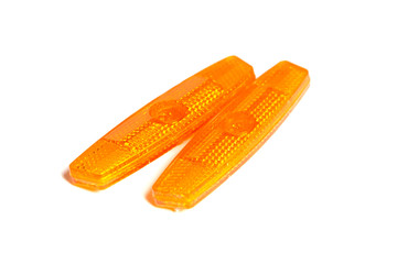 Bicycle wheel reflectors isolated on white background. Two orange plastic reflectors for a bike spoke for safety at night