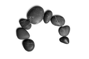Scattered sea pebbles. Smooth gray and black spa stones isolated on white background. Top view