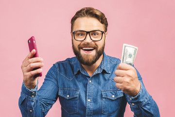Happy winner! Bearded happy man demonstrating his money prize and using smartphone isolated over...