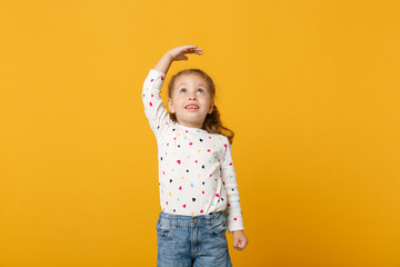 Little cute child kid baby girl 4-5 years old wearing light denim clothes isolated on pastel yellow wall background, children studio portrait. Mother's Day, love family, parenthood childhood concept.