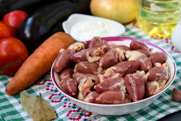 Raw chicken hearts and vegetables: carrots, eggplant, tomatoes and onions, for a tasty and healthy dinner, horizontal orientation