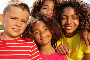 School age boy and girls in park group portrait