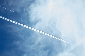 Jets. Two planes with trails in the blue sky with white clouds. The aircraft leaves traces