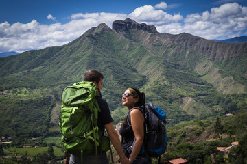 Fototapeta premium Backpacker couple holding hands surrounded by a natural landscape. Vilcabamba, Ecuador