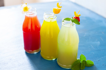 Fresh fruit, berry and vegetable juices on bright blue background.Homemade refreshing beverage