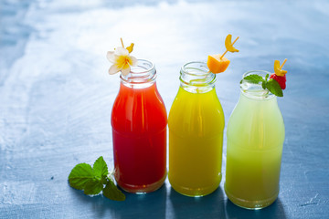 Fresh fruit, berry and vegetable juices on bright blue background.Homemade refreshing beverage