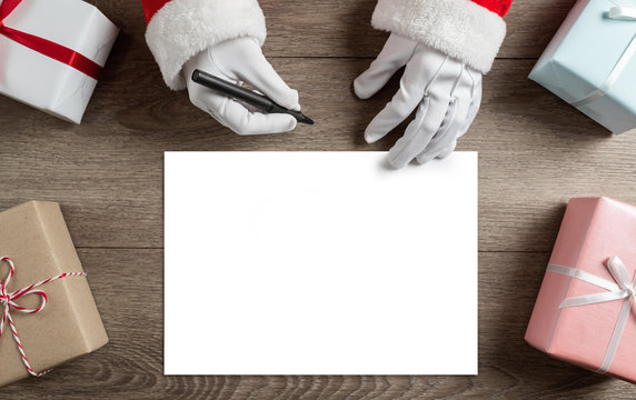 Santa Claus hands is writing to do list and goals in a blank paper sheet
