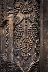 Ancient columns with Renaissance bas-reliefs and plants patterns in the wall