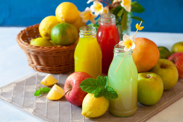 Fresh fruit, berry and vegetable juices on bright blue background.Homemade refreshing beverage