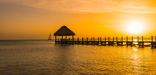 Fototapeta na wymiar beautiful orange sunset on the sea with a pier
