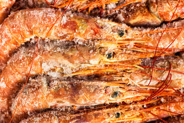 Obraz na płótnie Canvas Fresh red shrimps or prawn packing in box on slate stone background. Seafood, top view, flat lay, copy space