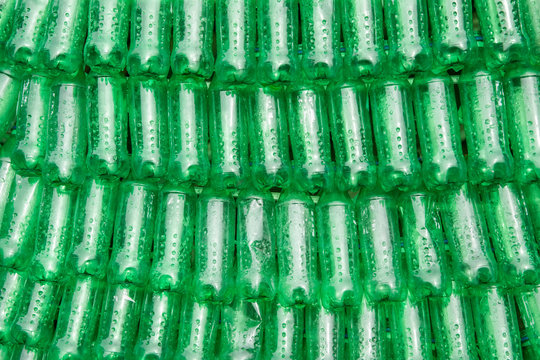 Rows of green plastic bottles stacked next to each other