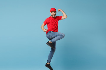 Fototapeta na wymiar Delivery man in red uniform workwear isolated on blue wall background, studio portrait. Professional male employee in cap t-shirt print working as courier dealer. Service concept. Mock up copy space.