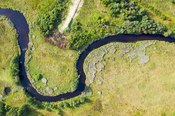Aerial view from drone on green summer forest, field and river