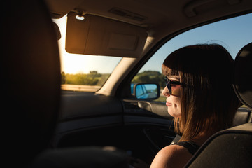Fototapeta premium A young and attractive girl with piercings travels by car with sunglasses.