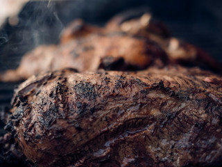 Grilled meats over the barbecue fire. You can see the smoke, the fire and the heat as well as the fiery ones of the melted fats when falling under the direct fire