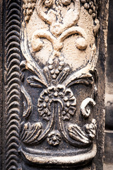 Ancient columns with Renaissance bas-reliefs and plants patterns in the wall