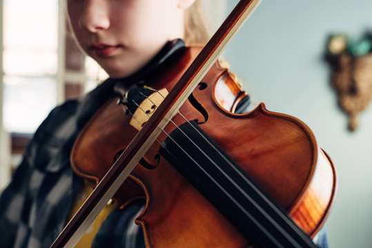 Close up of a violin played by a girl