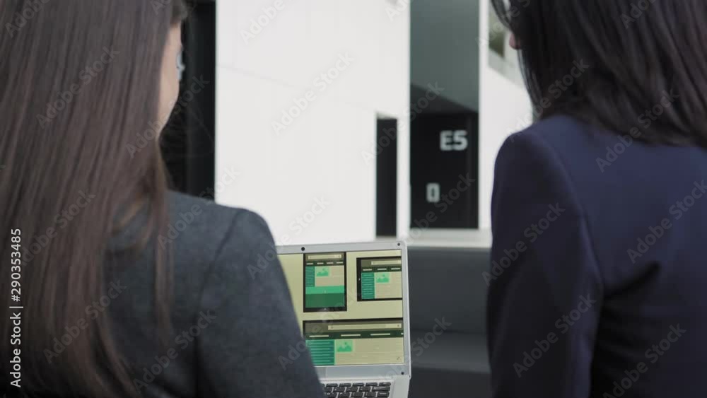 Wall mural tilt down back view of two female professionals, middle aged and young one, sitting in office lobby 