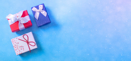 Fototapeta na wymiar Special gifts on a blue background. Three gift boxes, presents or surprises