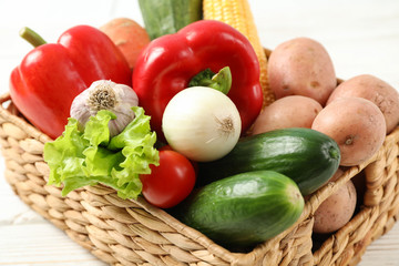 Wicker basket with vegetables on white background, close up