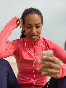 Content sportive girl surfing phone outside