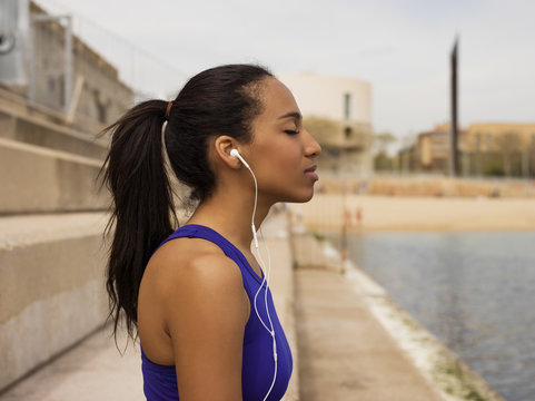 Relaxing sportive girl enjoying music