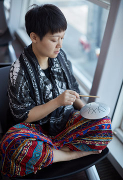 Asian women pounding instruments - 'empty drums' ,in airport, On the journey