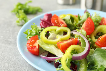 Salad of fresh vegetables on grey background, close up